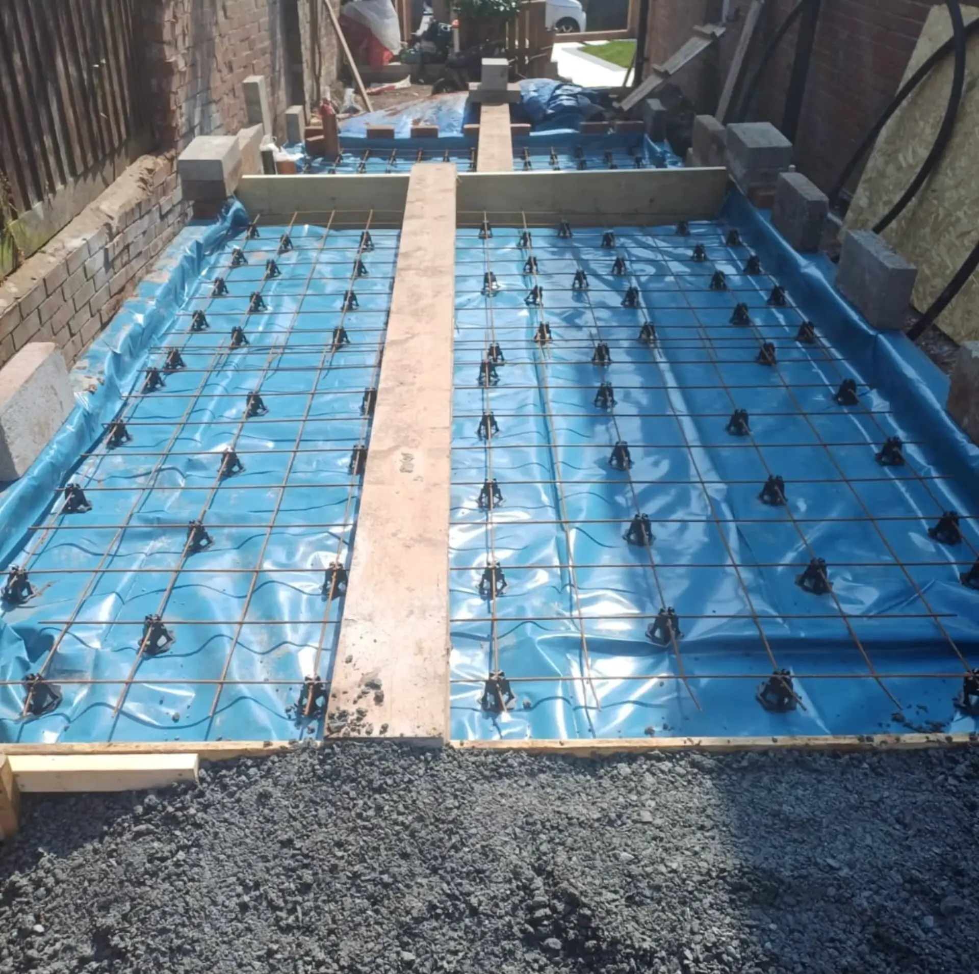 CMD groundworker laying a damp proof membrane over new foundations